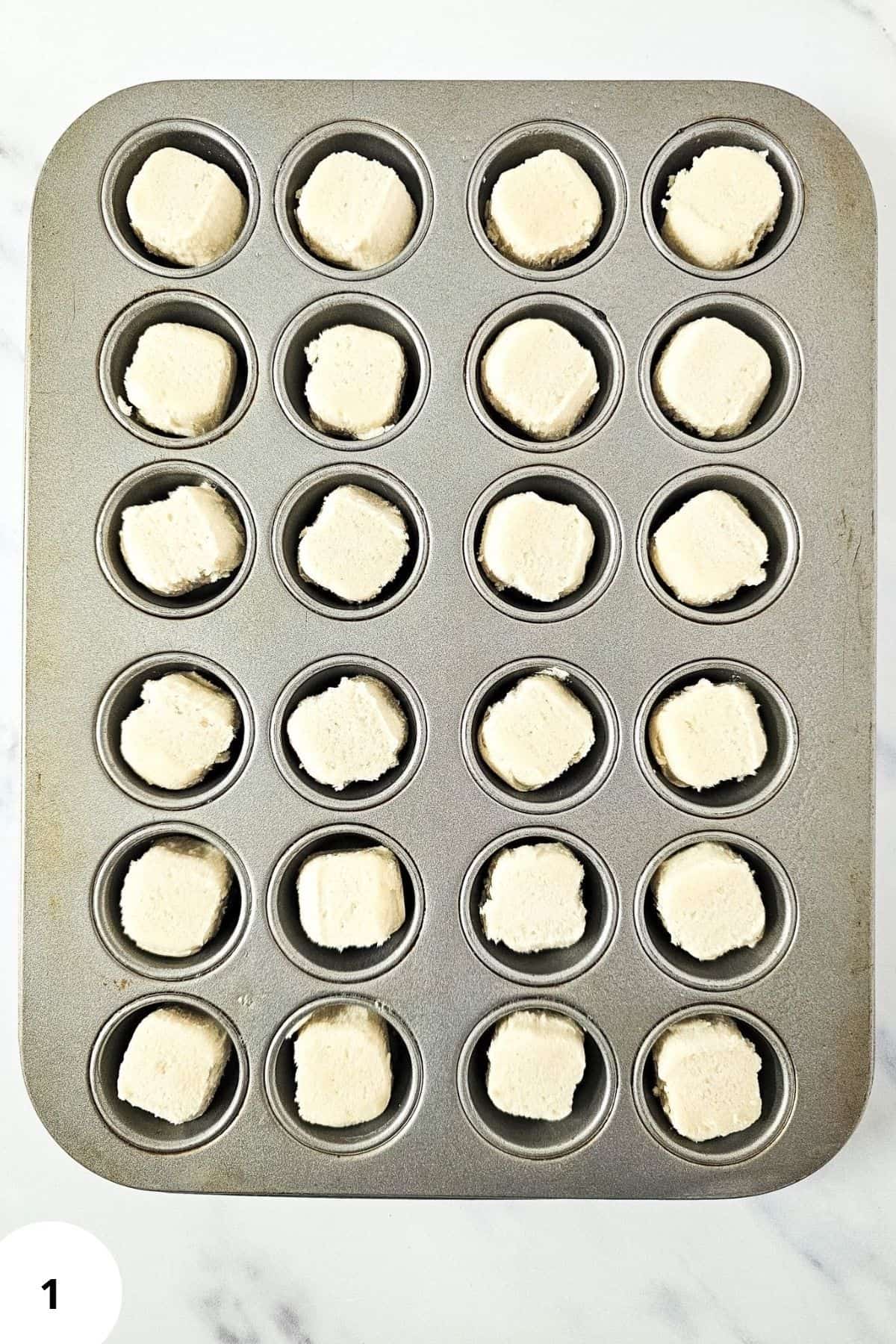 Baking tray lined with raw cookie dough balls ready for the oven.