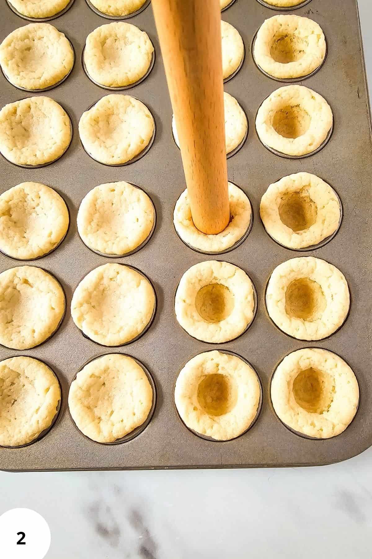 Cookie dough with its center being pressed down to form a well.