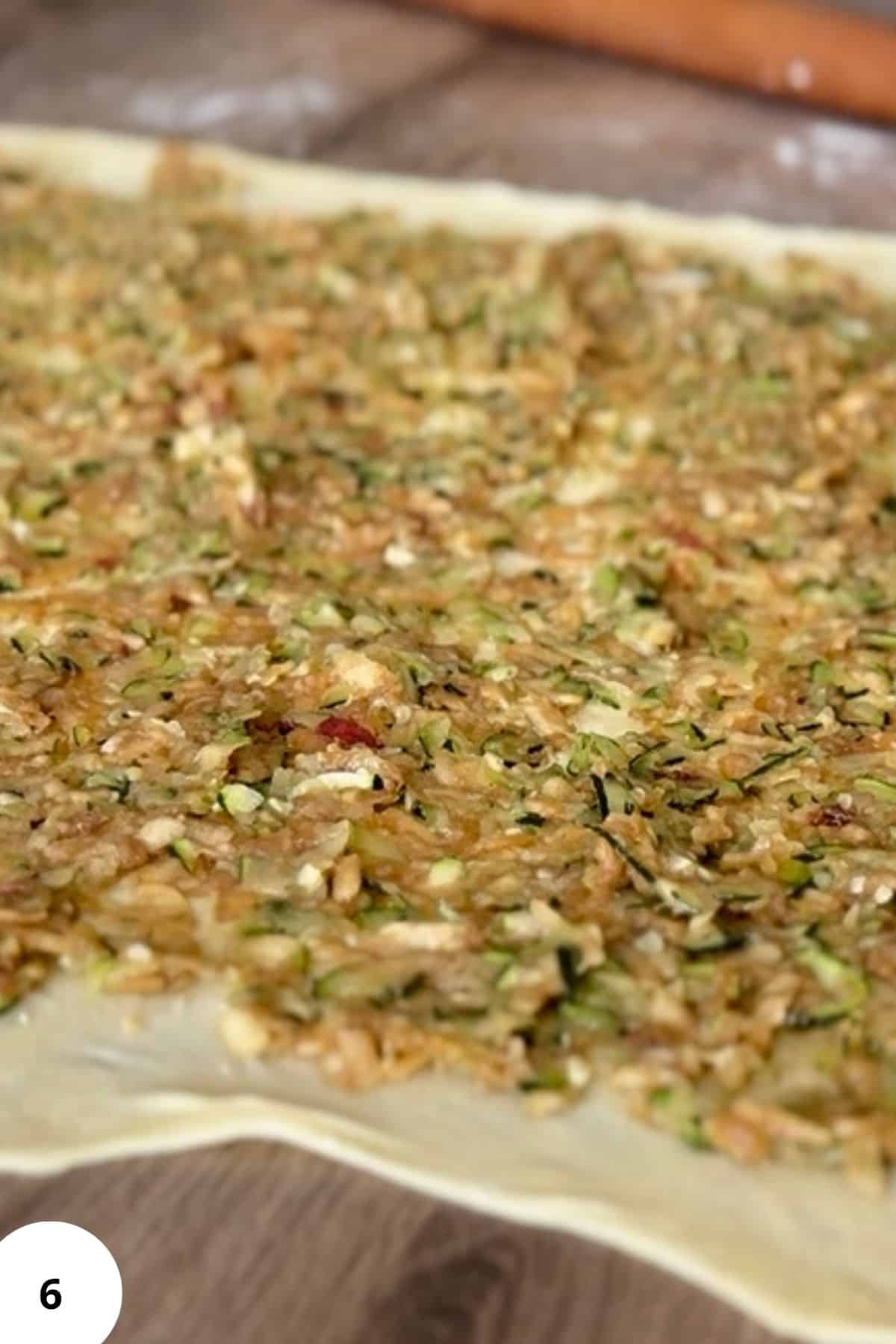 Close-up of dough topped with strudel filling mixture.