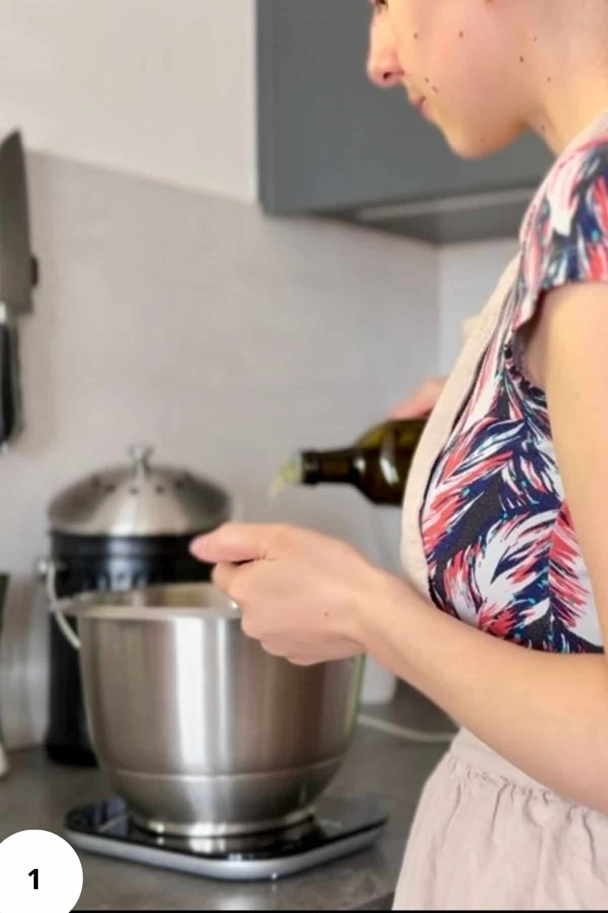 A person pouring oil into a mixing bowl with ingredients.