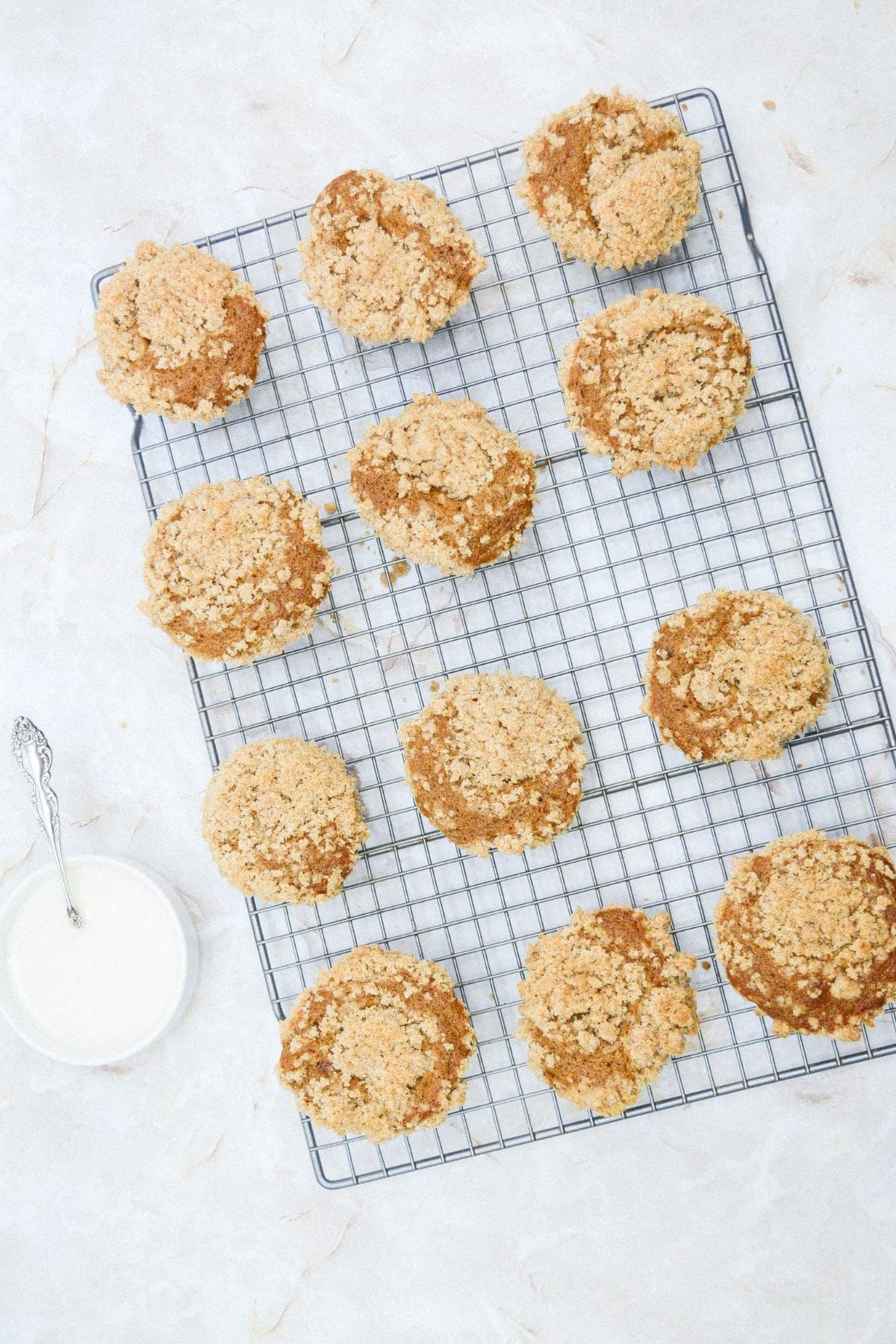 Pumpkin streusel muffins cooling on a rack.