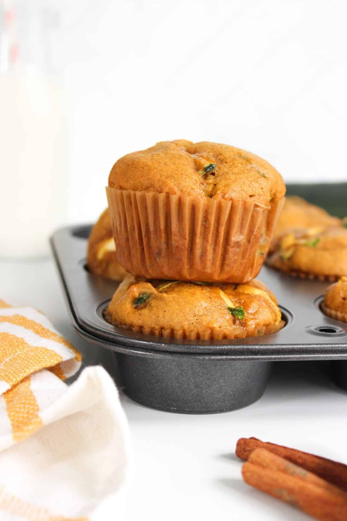 Stacked muffins in a baking tray.