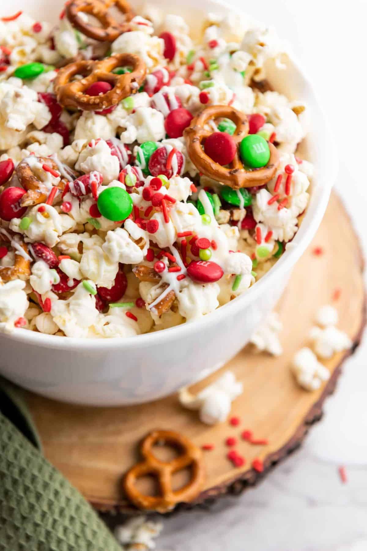 Christmas Popcorn served in a bowl placed on a wooden board.