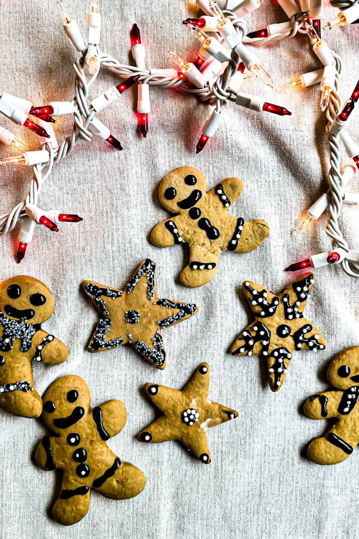 Sourdough gingerbread cookies resting on a surface with Christmas ornaments placed beside them.