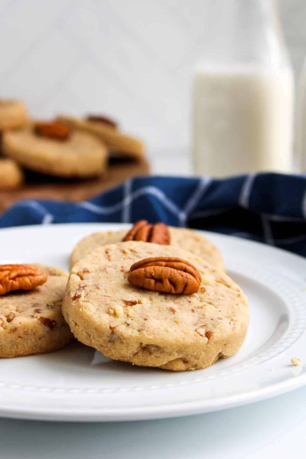 A plate with buttery pecan cookies and cloth underneath.