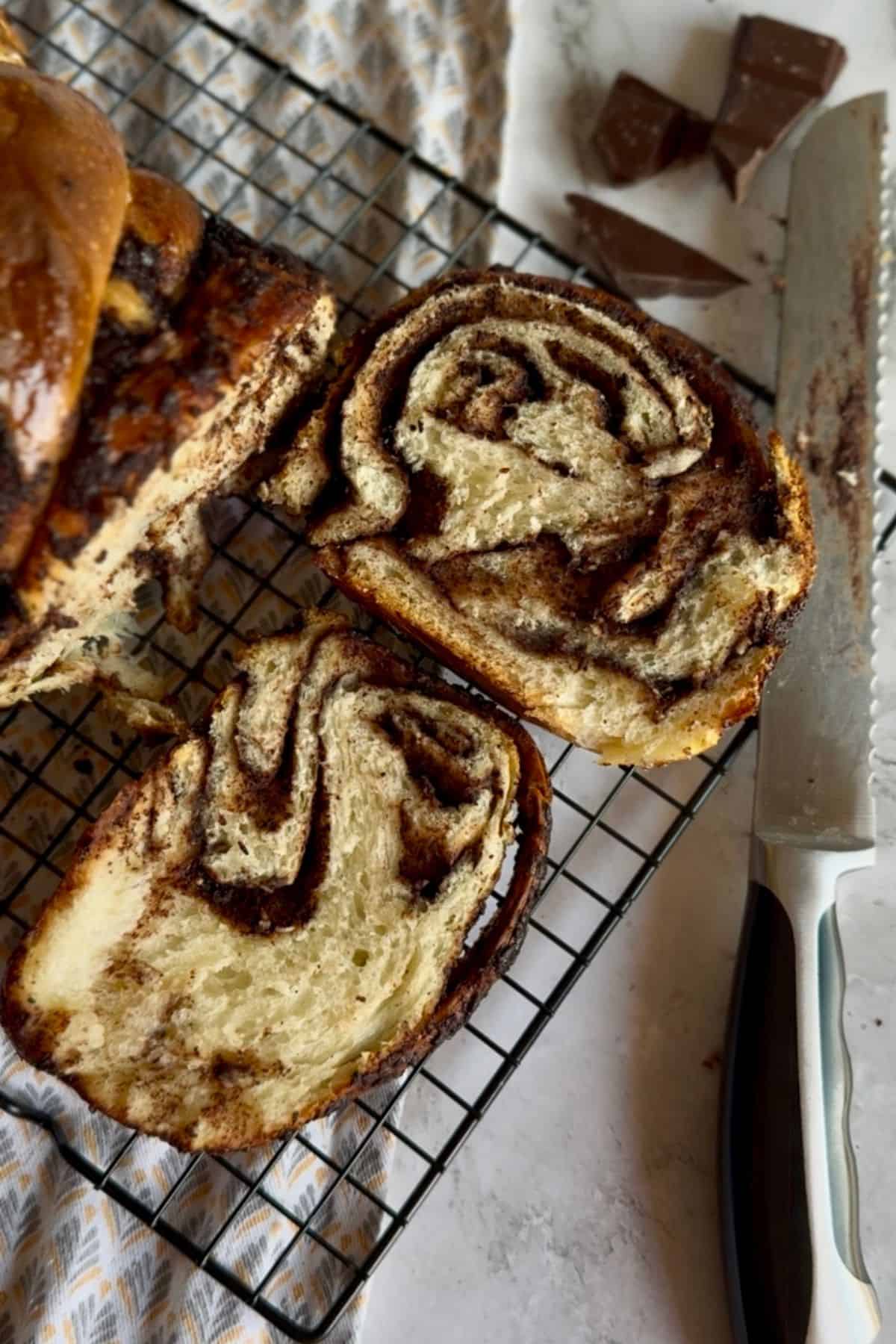 Slices of chocolate sourdough babka resting on a wire cooling rack.