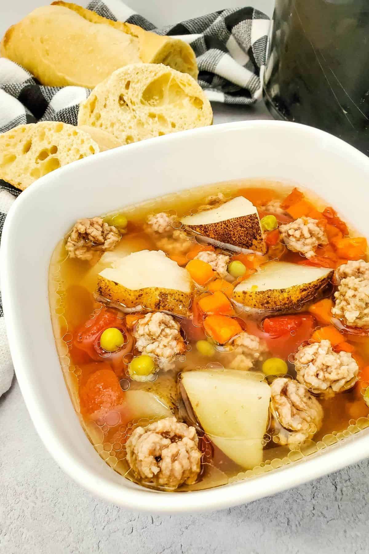 Close-up of Crockpot Beef Vegetable Soup in a bowl, filled with tender beef, carrots, potatoes, and broth.
