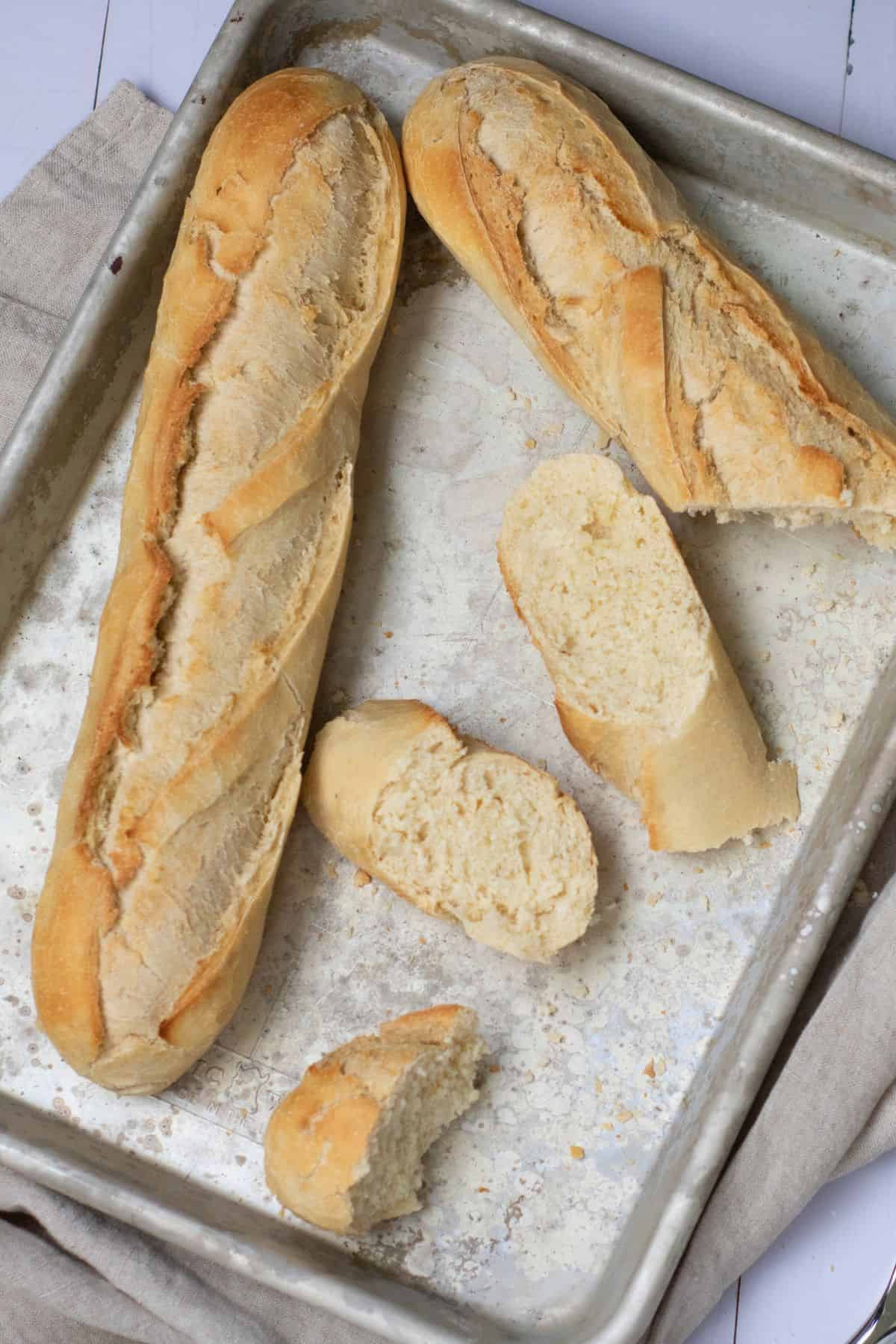 French baguette slices arranged in a baking tray, ready to serve or toast.
