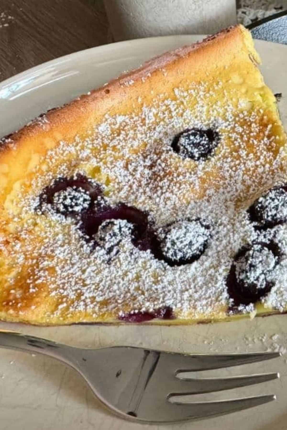 Dutch pancake topped with powdered sugar and fresh blueberries.