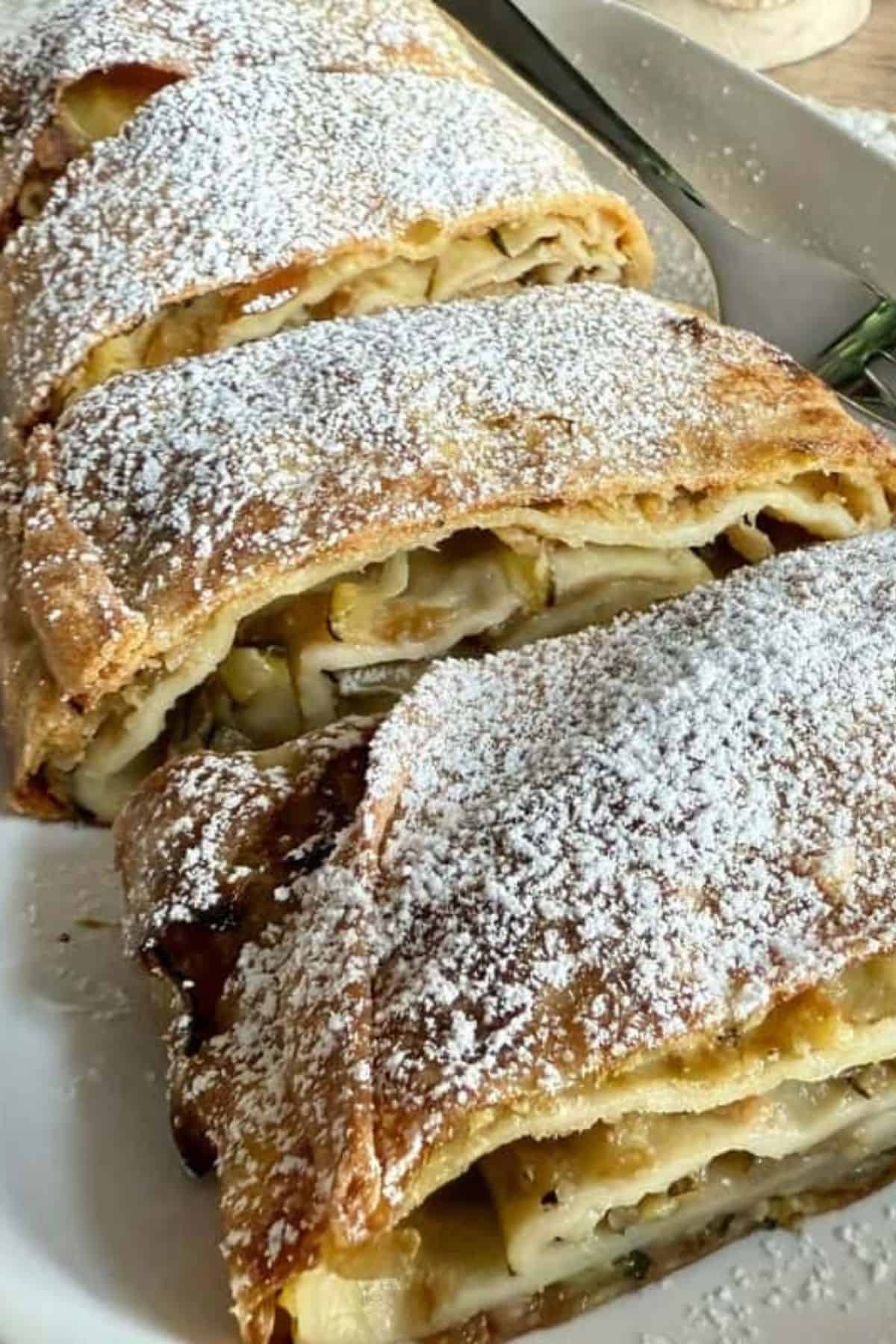 Sliced apple zucchini strudel arranged neatly on a plate.