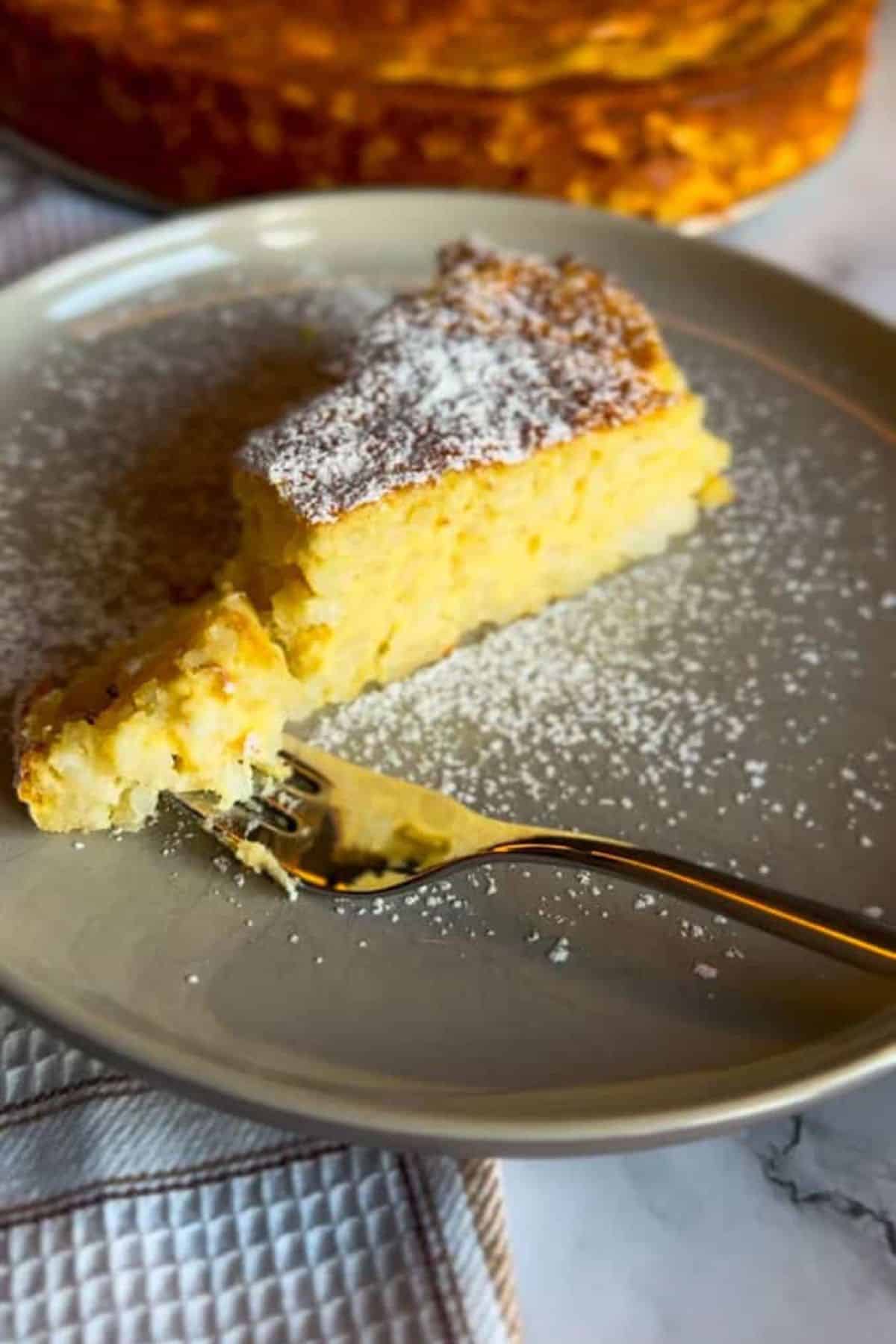 Oven-baked rice pudding served on a plate with a fork resting beside it.