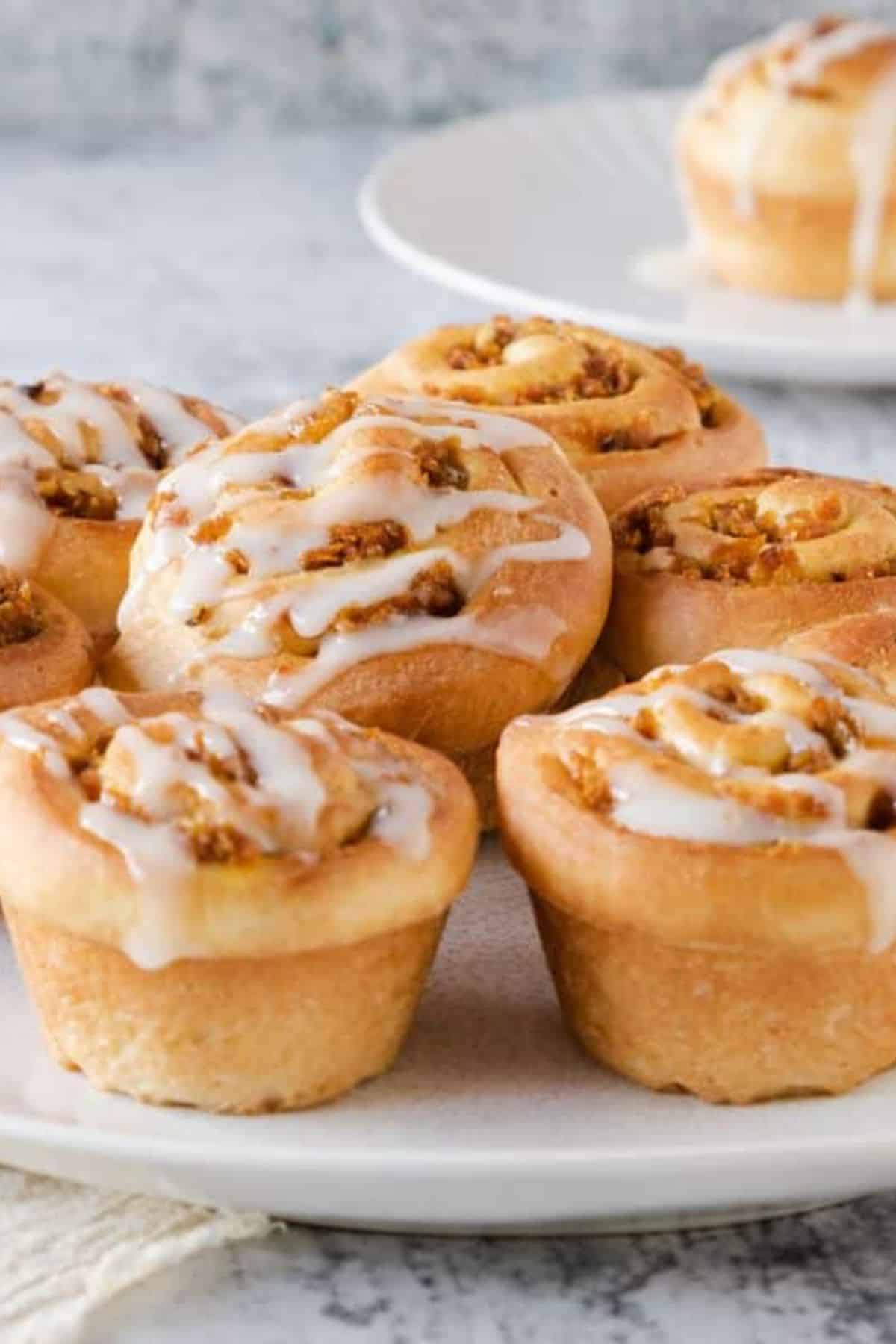 Carrot Cake Cruffins drizzled with cream cheese glaze and served on a plate.