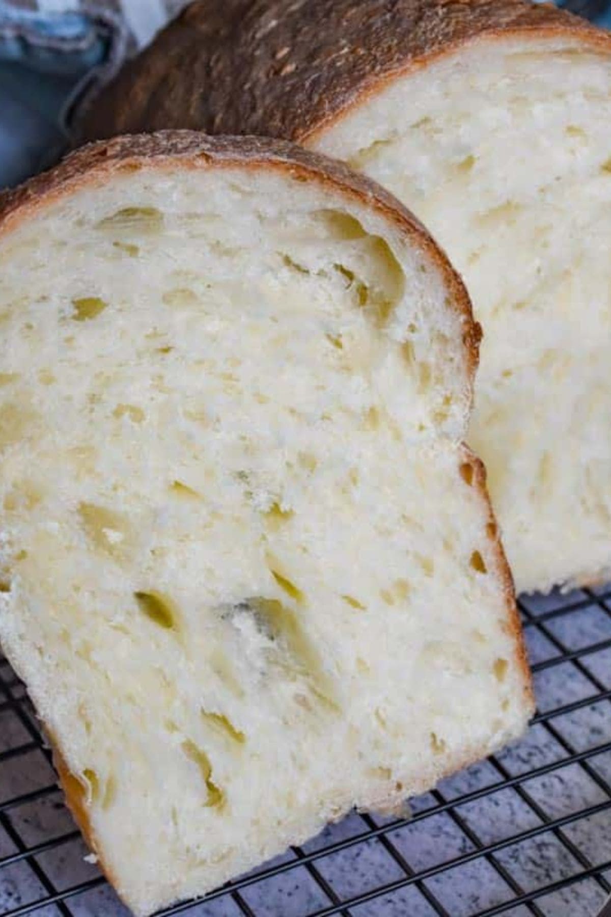 Sliced sourdough bread arranged on a wire cooling rack.