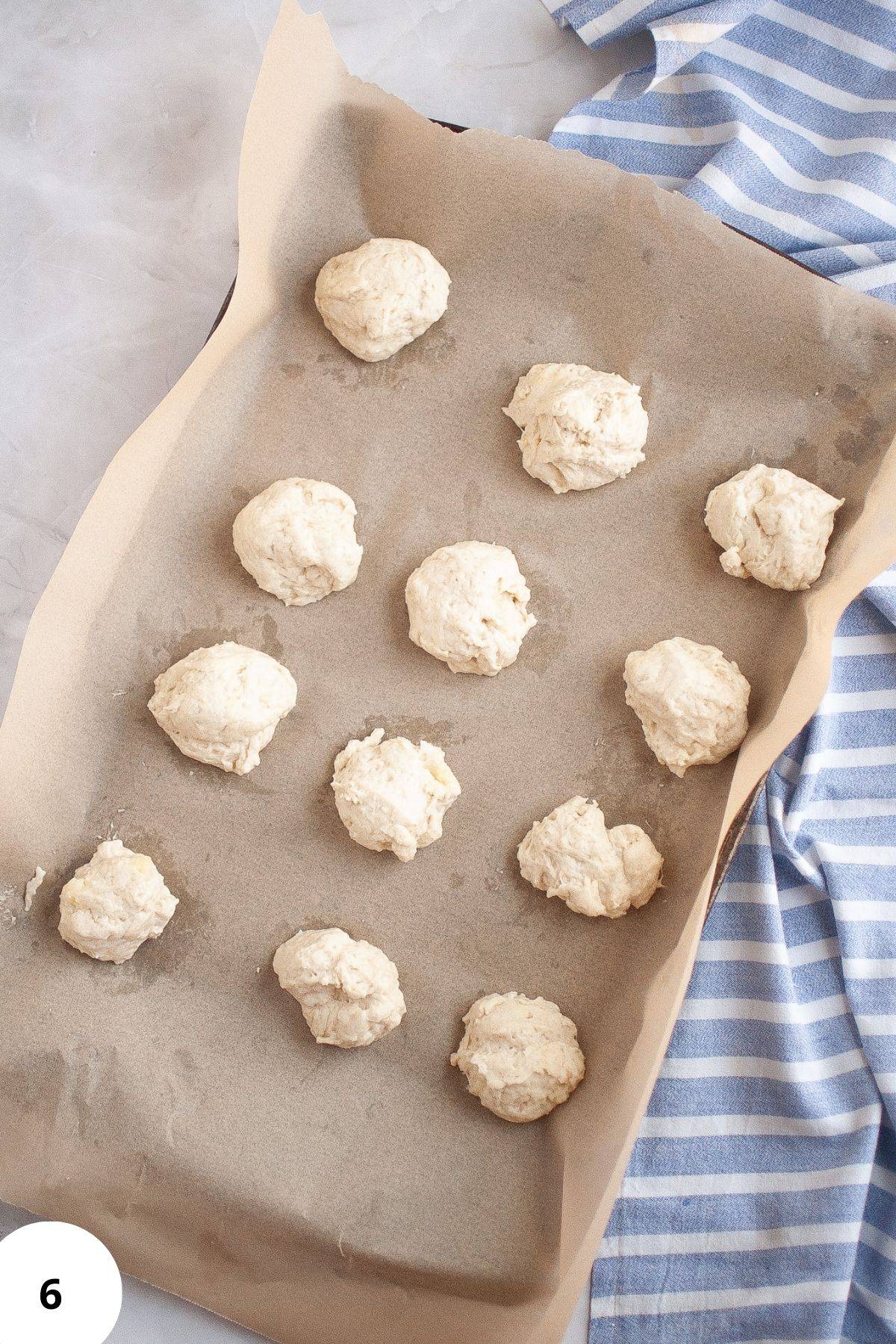 Round shaped dough resting on parchment paper.