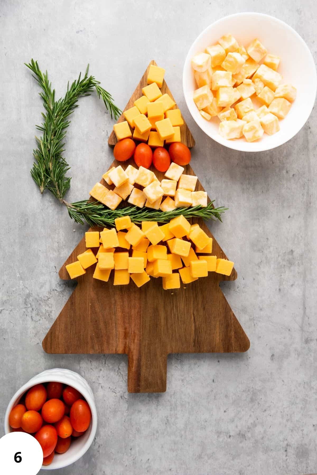 Ingredients arranged on a Christmas tree-shaped board with festive decorations around.