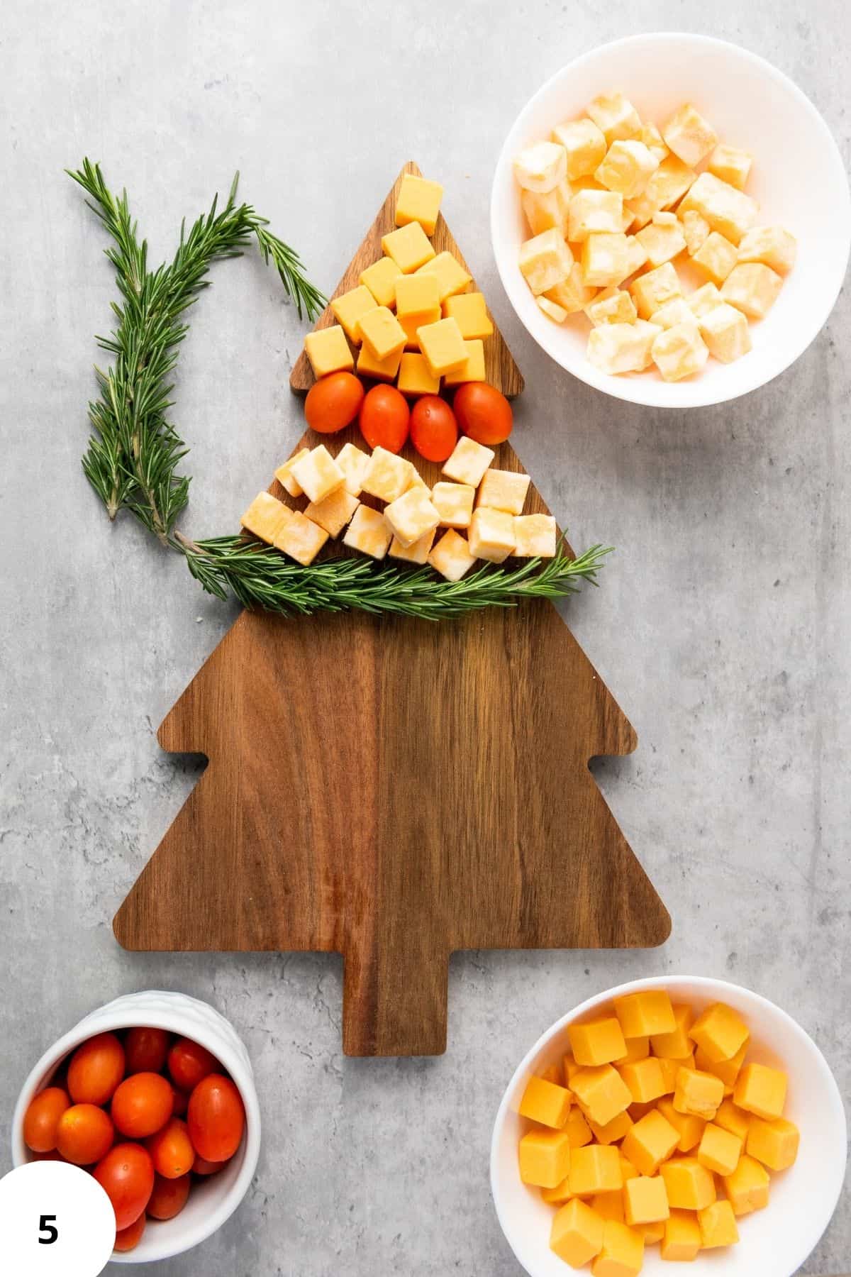 Ingredients arranged on a Christmas tree-shaped board with festive decorations around.