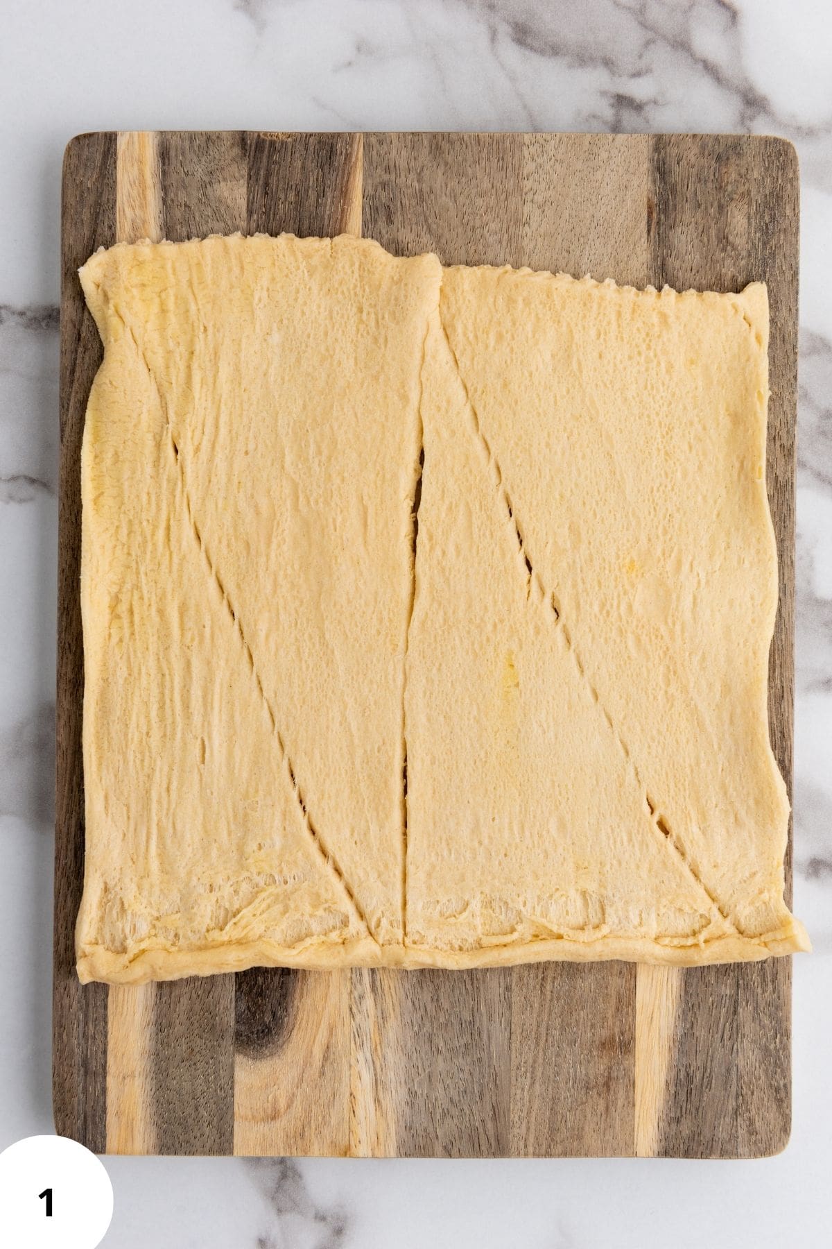 A dough placed on a wooden board with a slice cut to show texture.