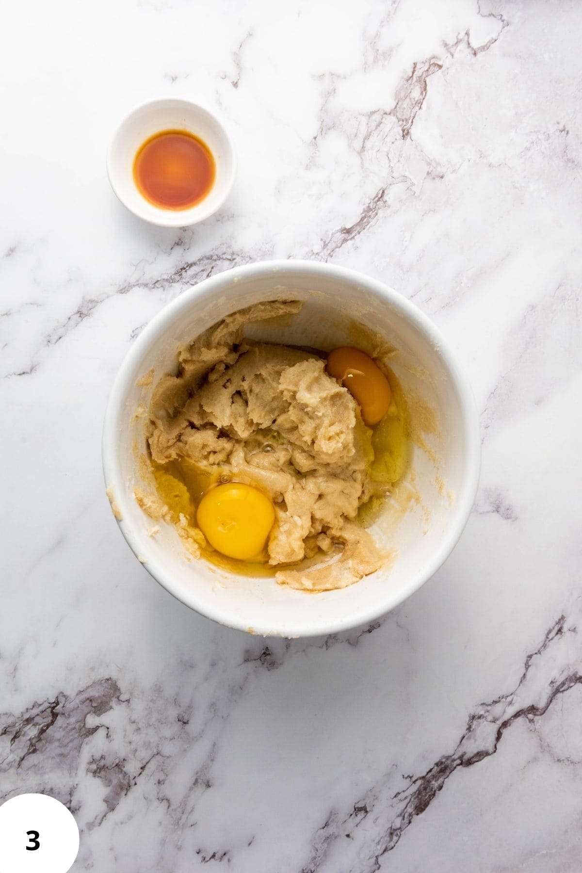 Cookie ingredients being mixed in a bowl with ingredient on the side.