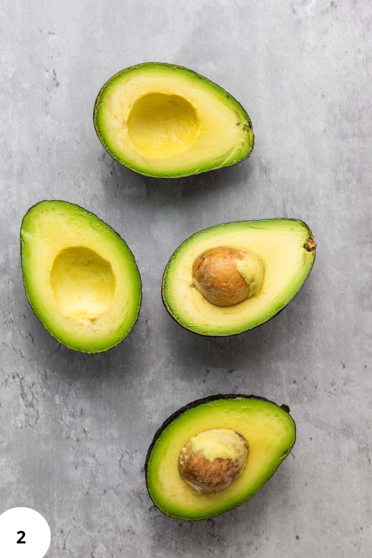 Fresh avocado slices arranged on a surface, ready for use in recipes.