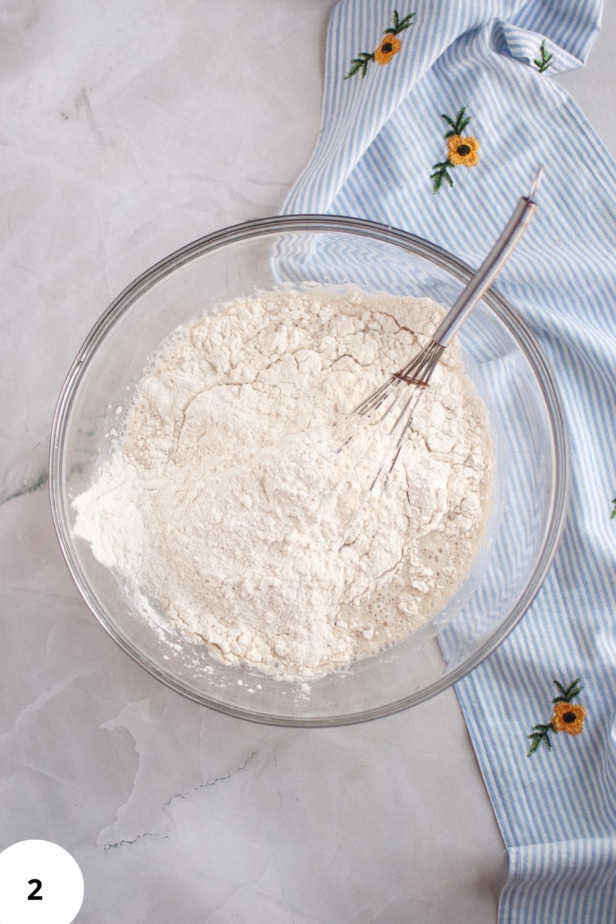 Ingredients being mixed in a large bowl with a whisk resting on the side.