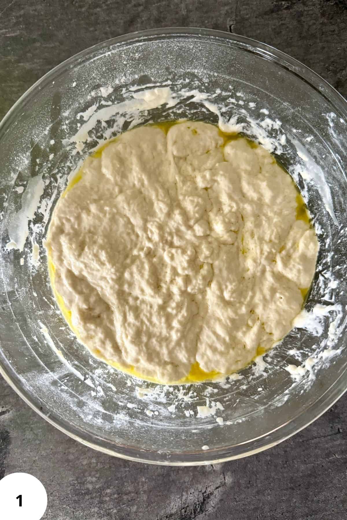 A dough being placed into a mixing bowl.