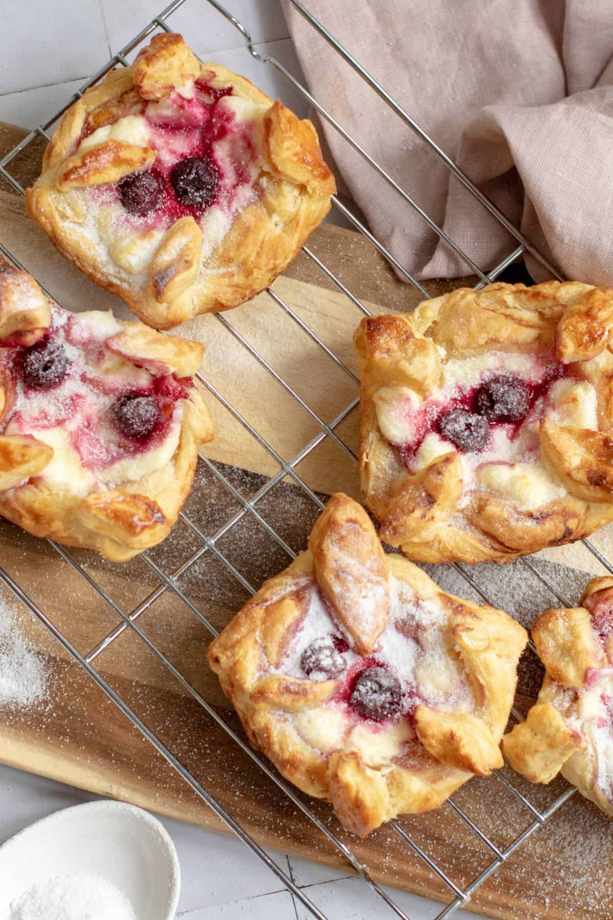 Danish pastries filled with blueberries, cooling on a wire rack.