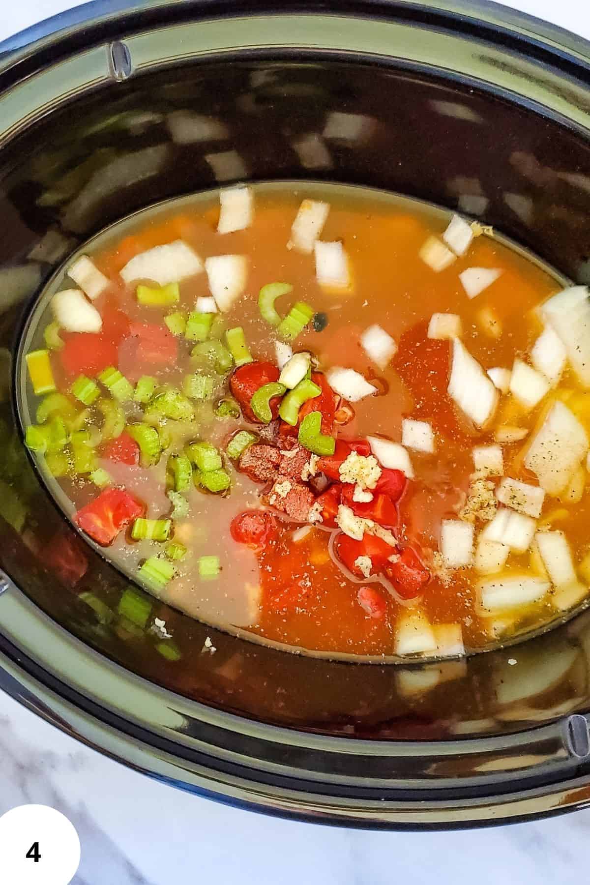 Ingredients soaking in a crockpot filled with vegetable broth.
