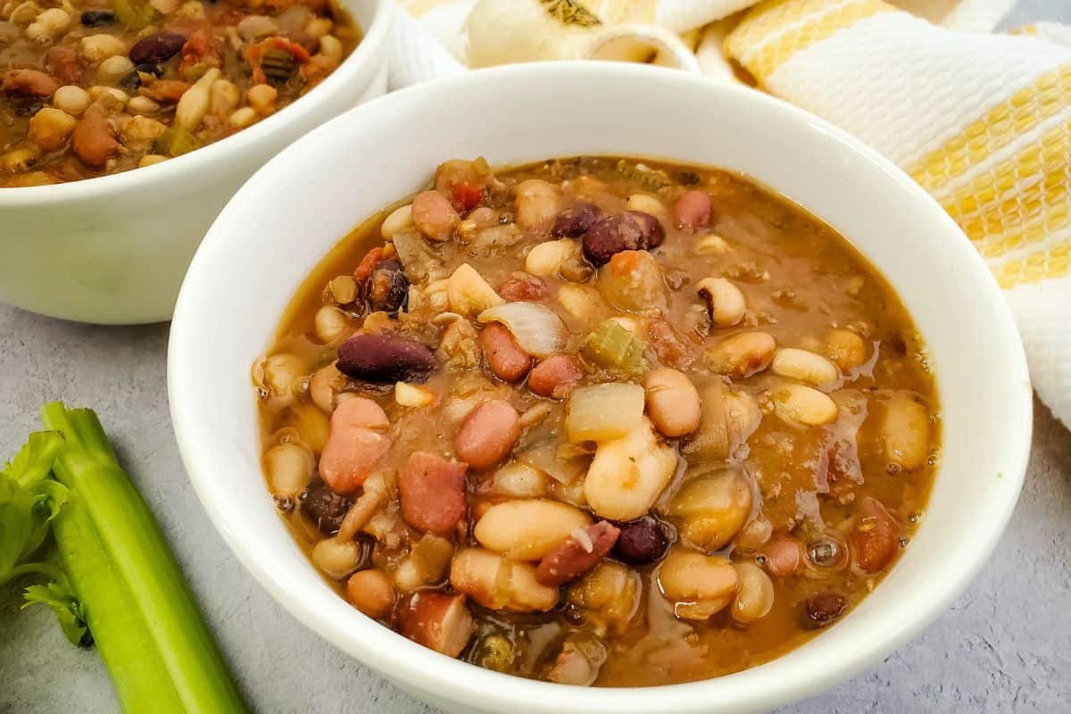 Close-up view of vegan bean soup served in bowls, showing tender beans, vegetables, and rich broth.