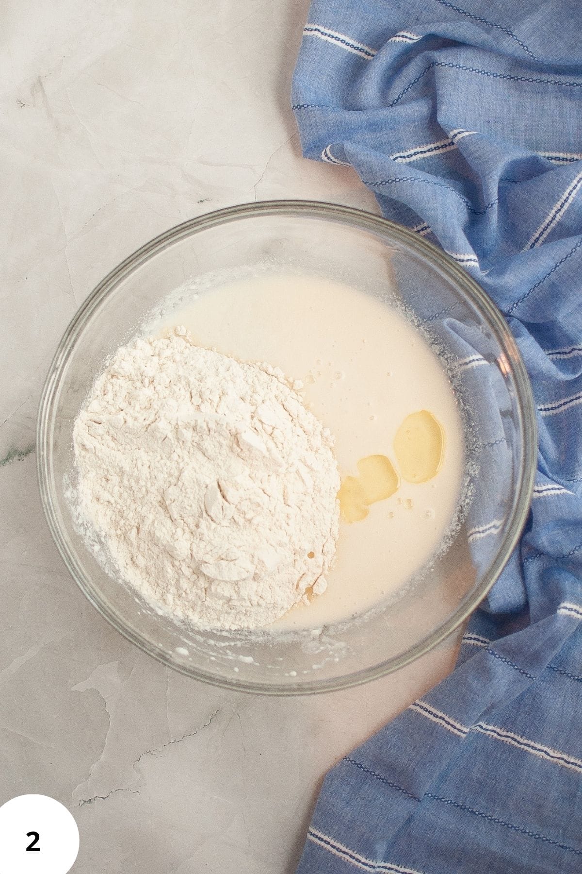 Ingredients being mixed in a large bowl with table napkin on the side.