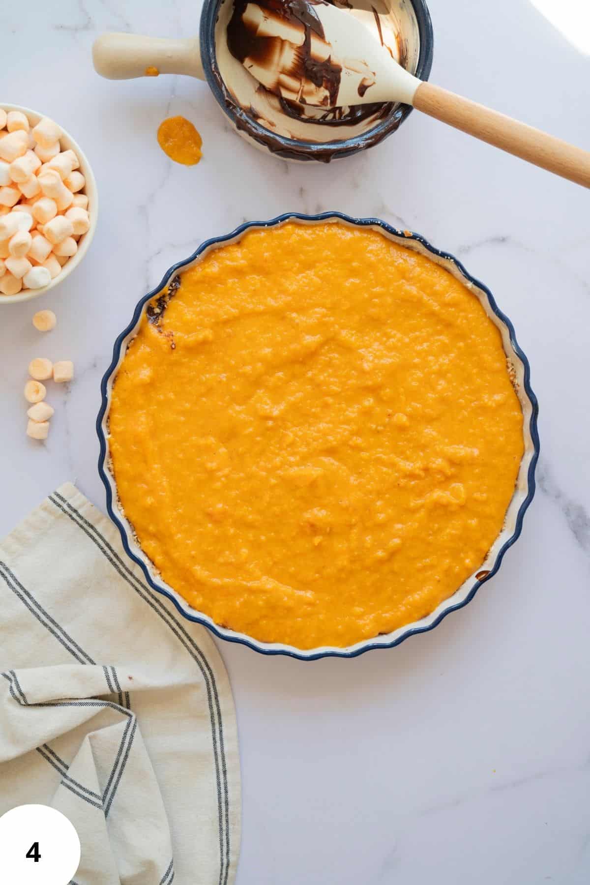 Sweet pie with mashed sweet potato and pumpkin filling, surrounded with other ingredients.
