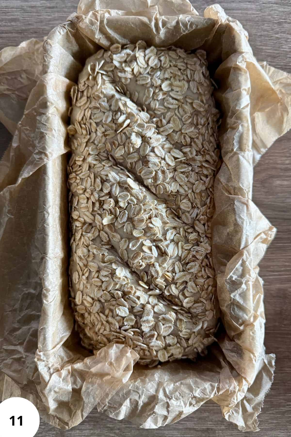 Loaf of bread in a parchment-lined baking pan.
