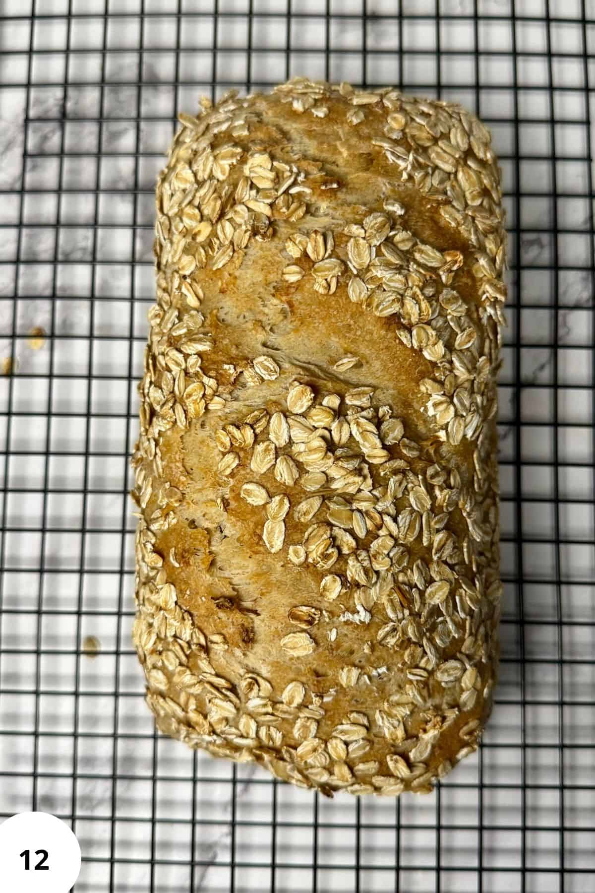 Freshly baked loaf of bread resting on a wire cooling rack.