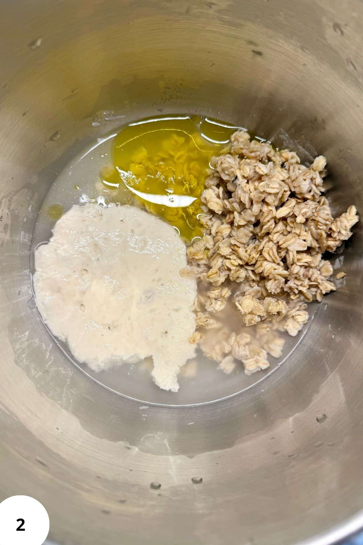Bread ingredients being mixed in a stand mixer to form dough.