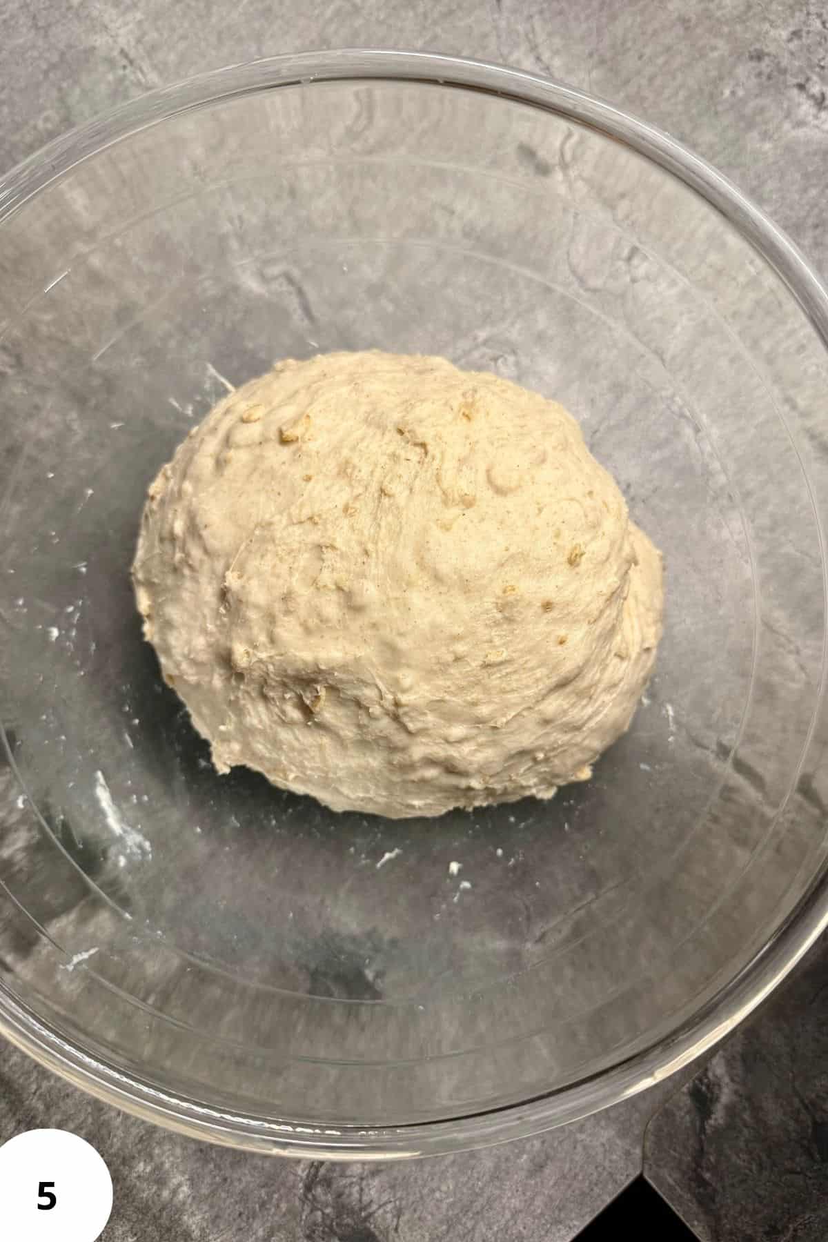 Round ball of dough resting in a bowl