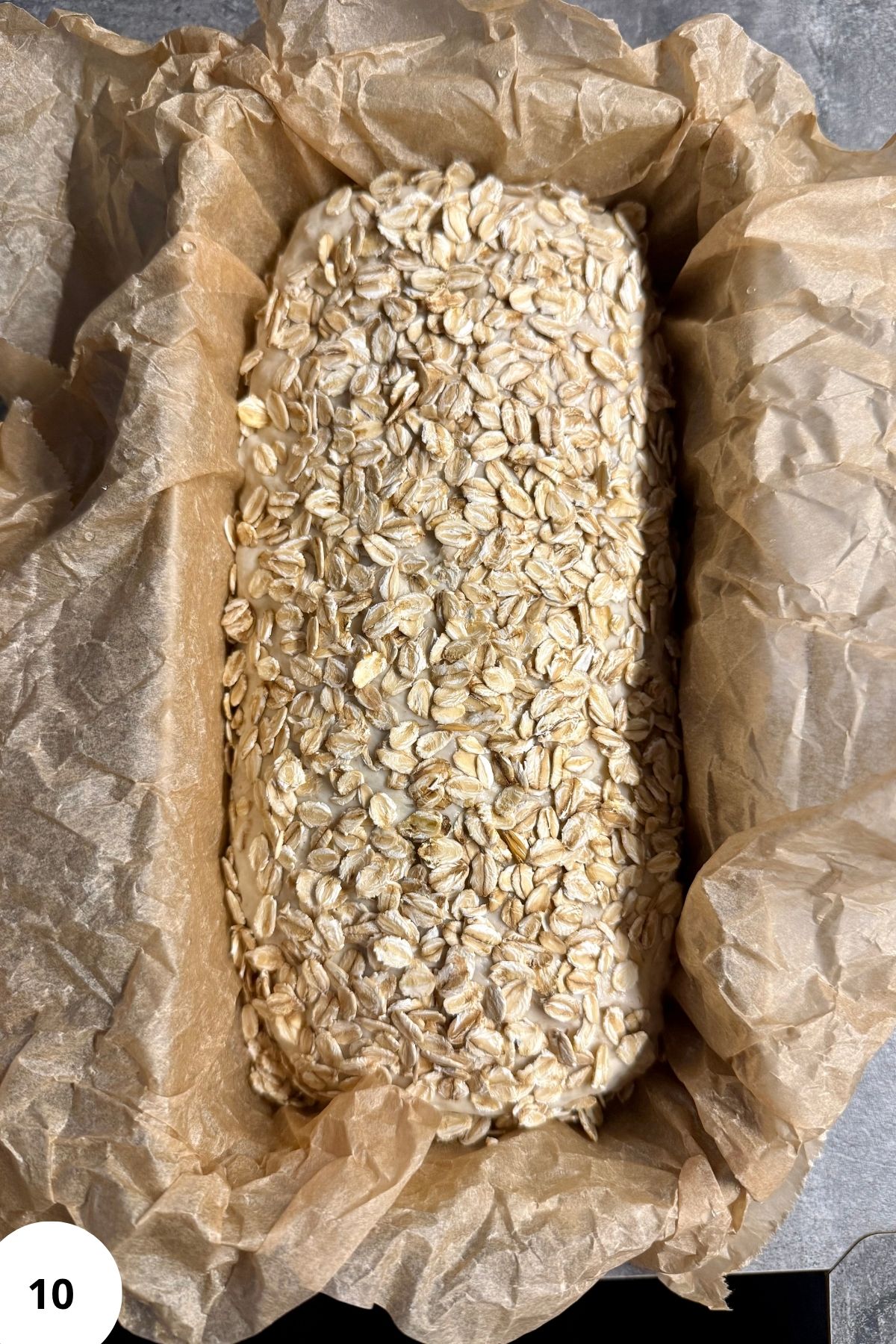 Loaf of bread in a parchment-lined baking pan.