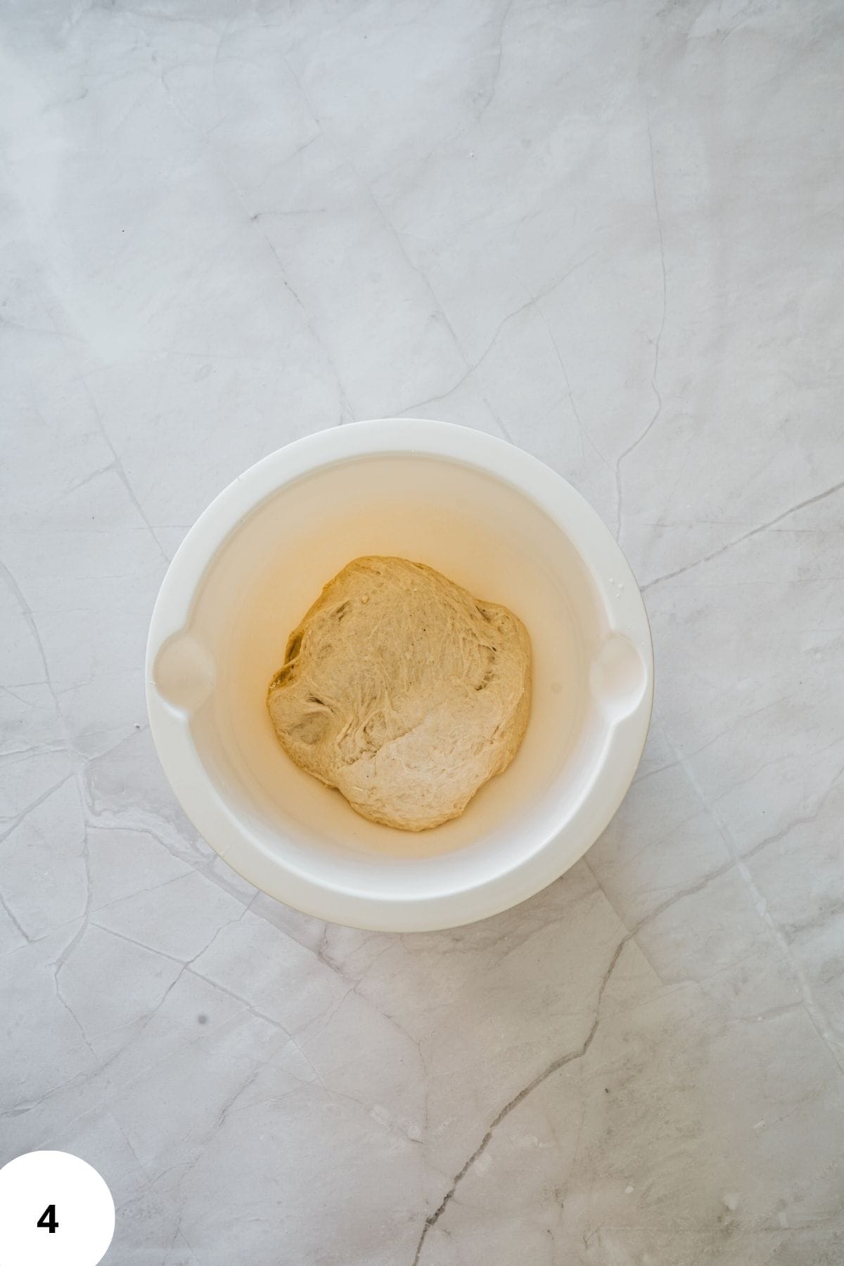 Donut dough resting in a large mixing bowl after kneading.