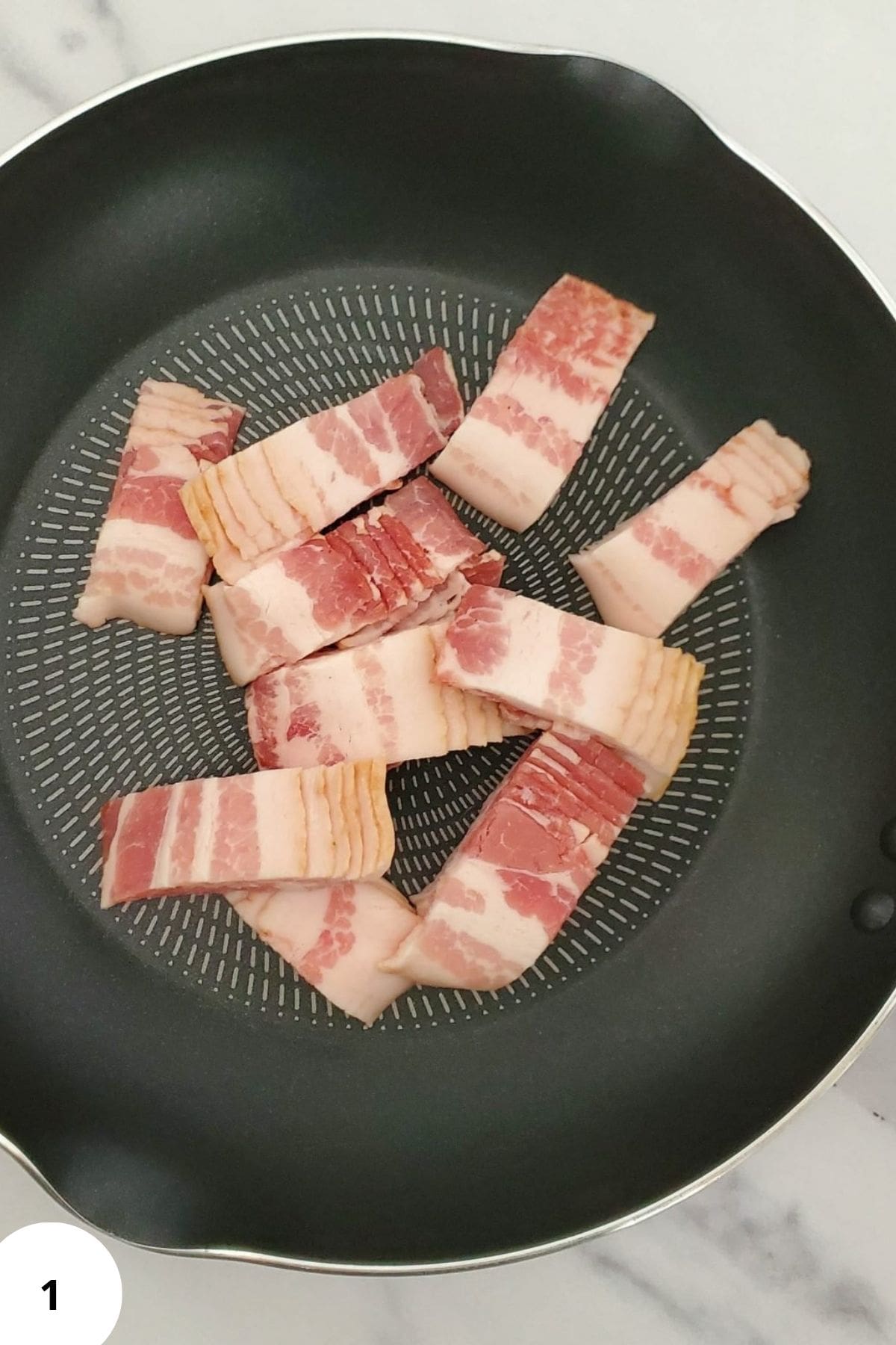 Sliced bacon cooking in a skillet with seasonings.