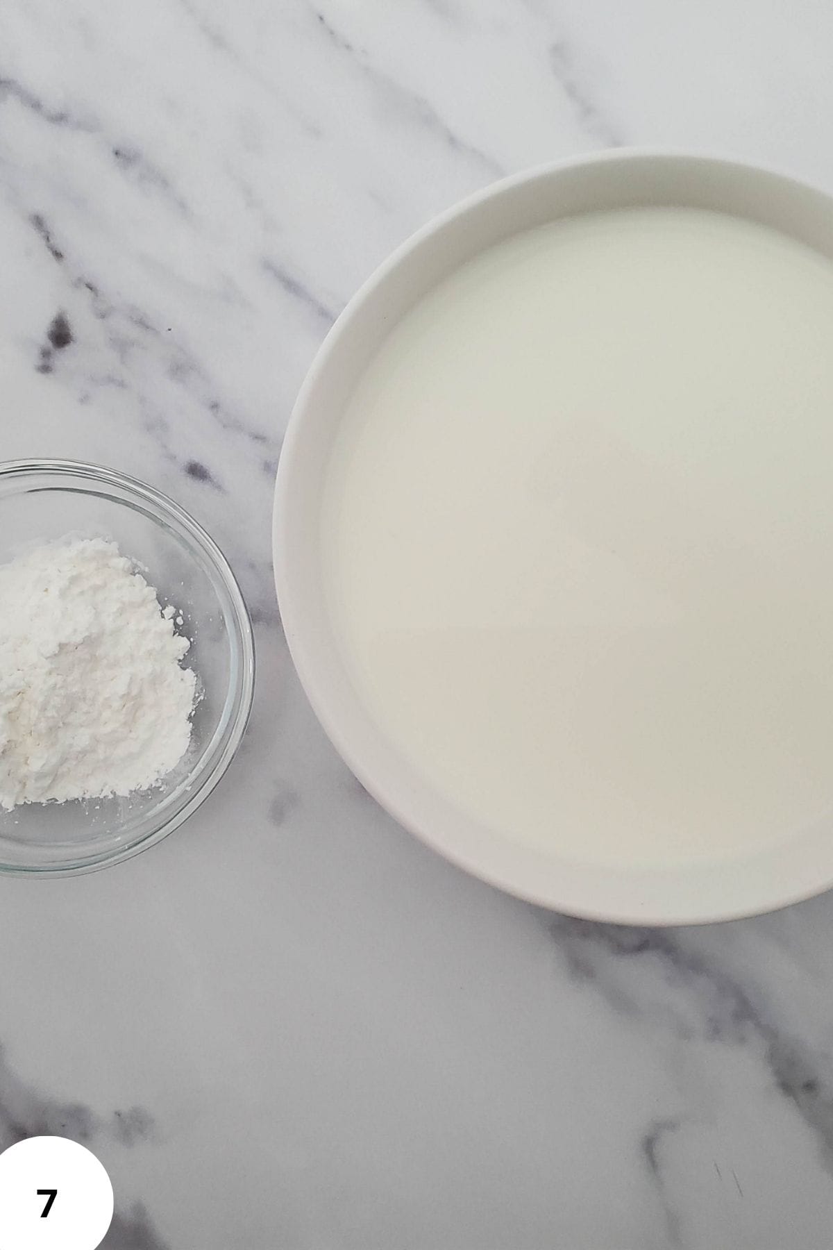 A bowl containing cornstarch mixed with milk, ready to be mixed.