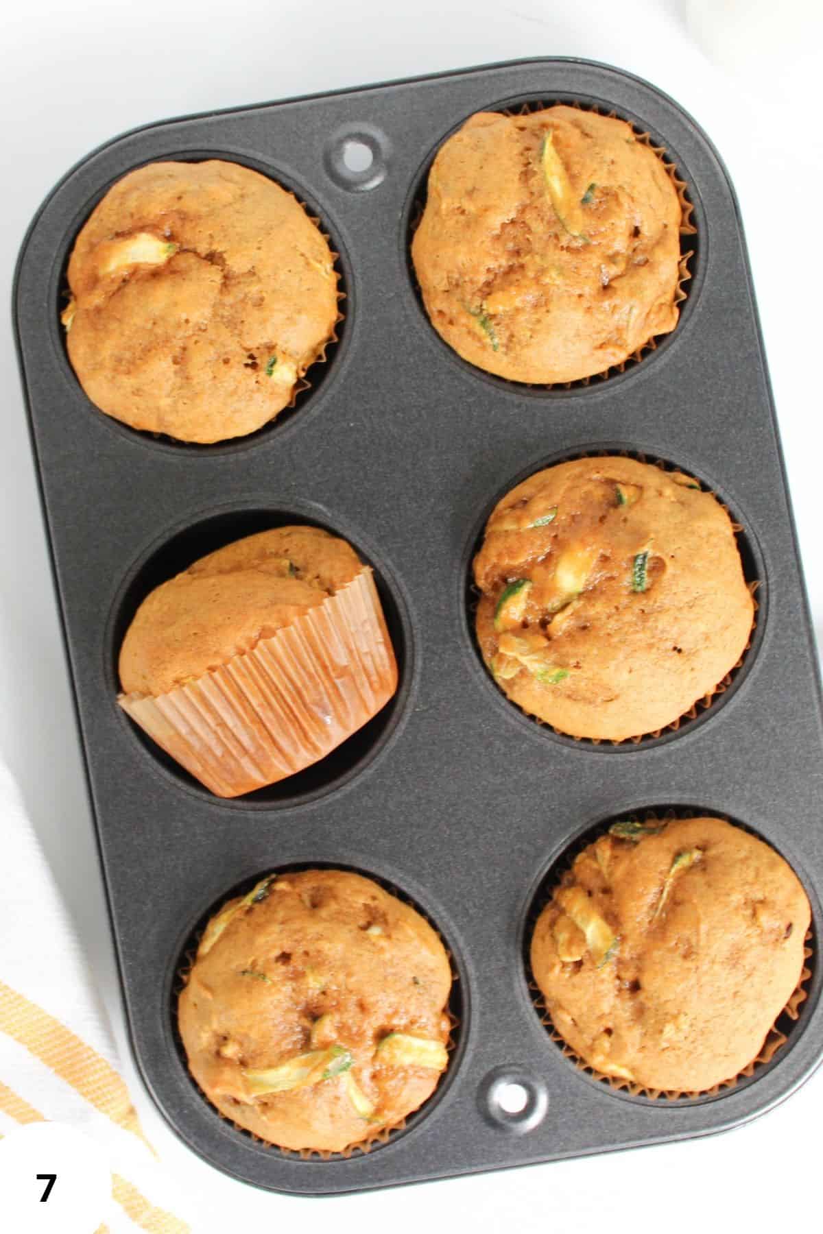Freshly baked pumpkin zucchini muffins in a baking tin, golden on top and just out of the oven.