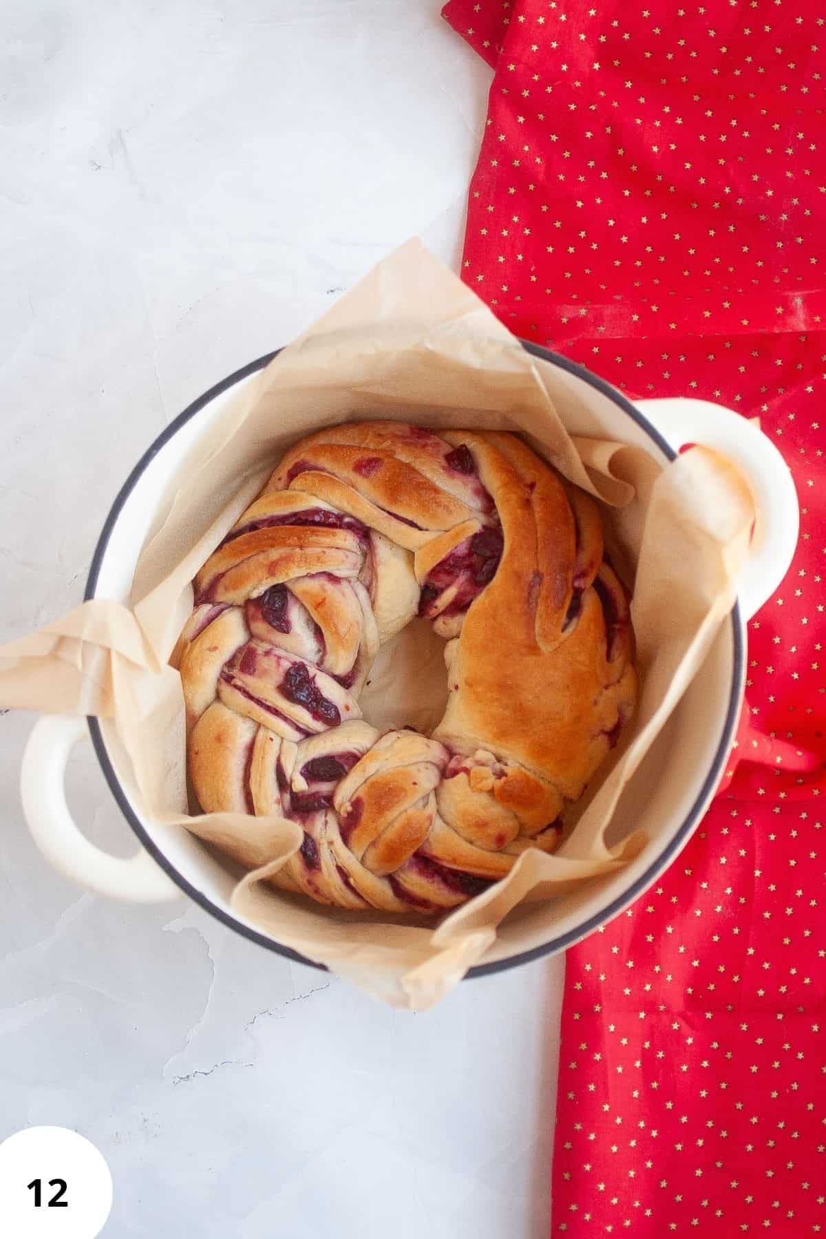 Freshly baked sourdough in a Dutch oven with parchment paper.
