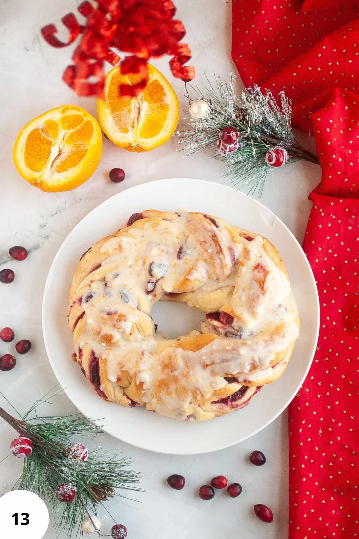 Cranberry bread on a plate with Christmas ornaments around it.