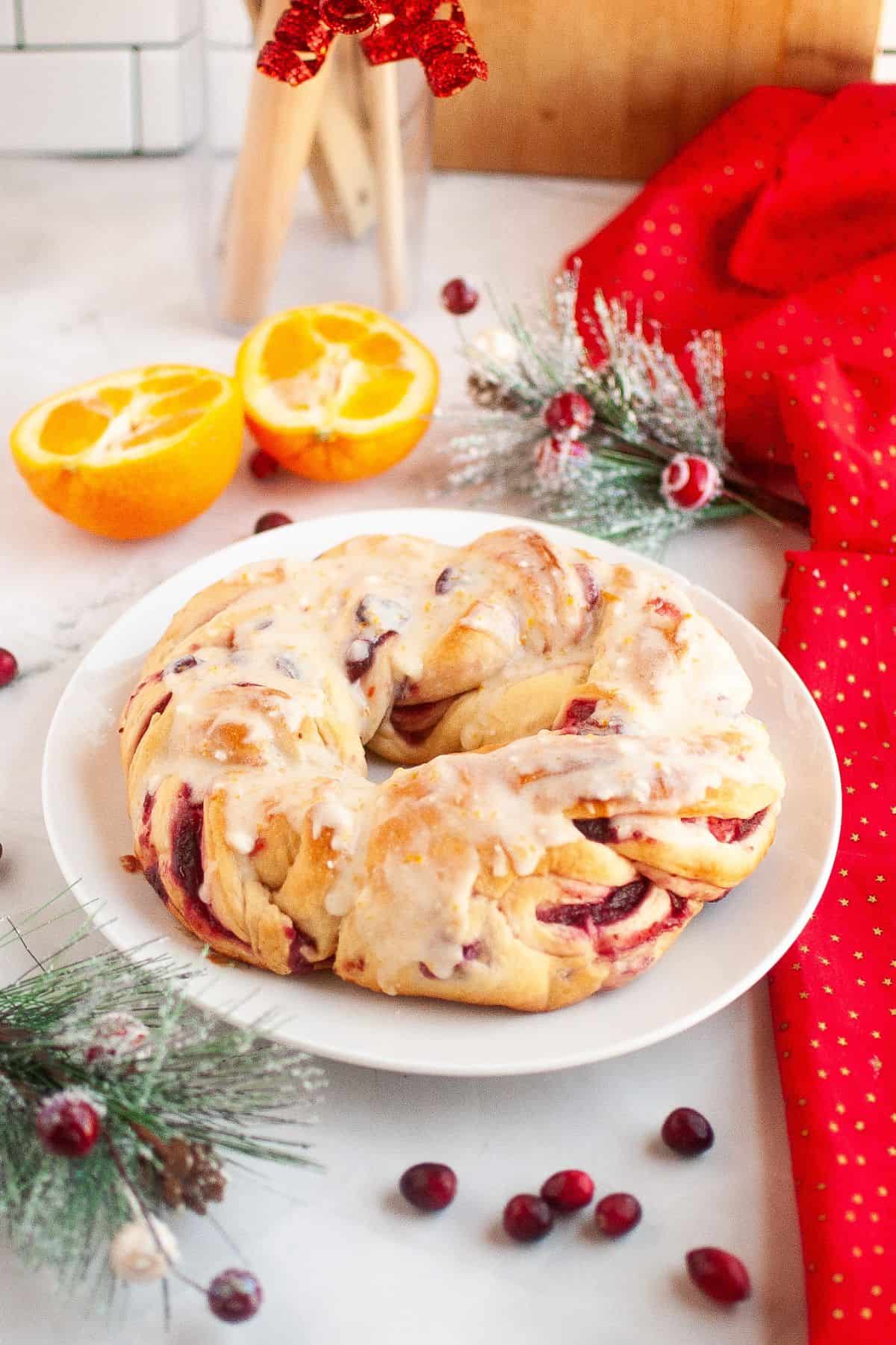 Cranberry bread on a plate with Christmas ornaments around it.
