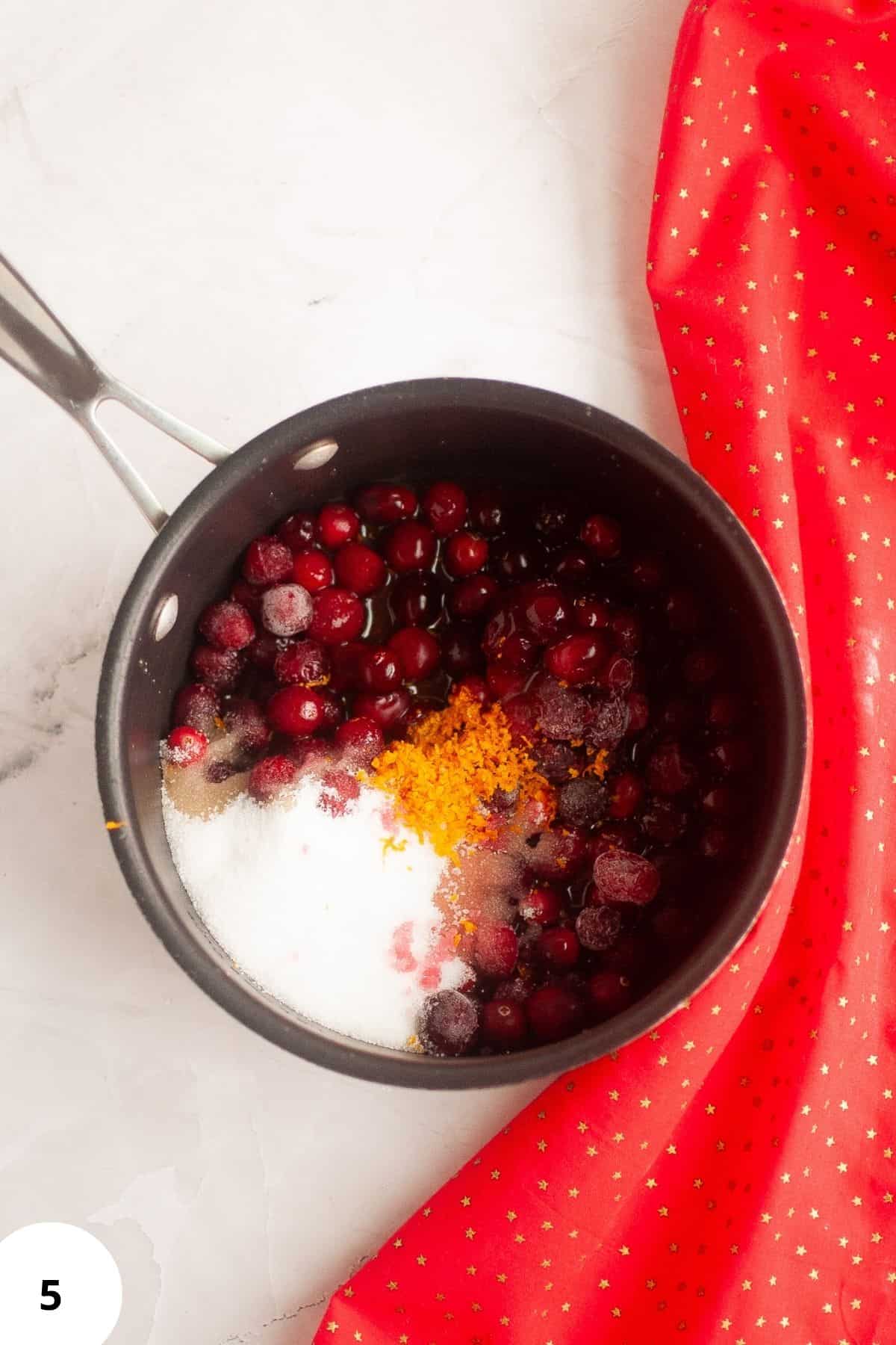 Ingredients for cranberry sauce in a saucepan.