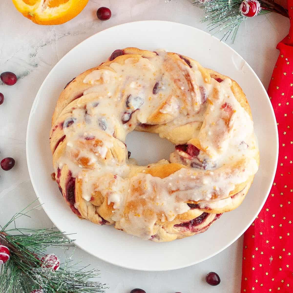 Cranberry bread on a plate with Christmas ornaments around it.