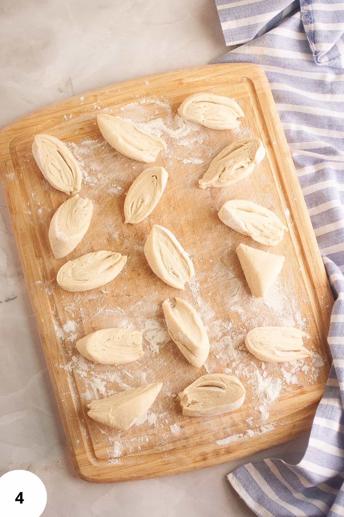 Pieces of sourdough brioche dough on a floured wooden surface, ready to be shaped.