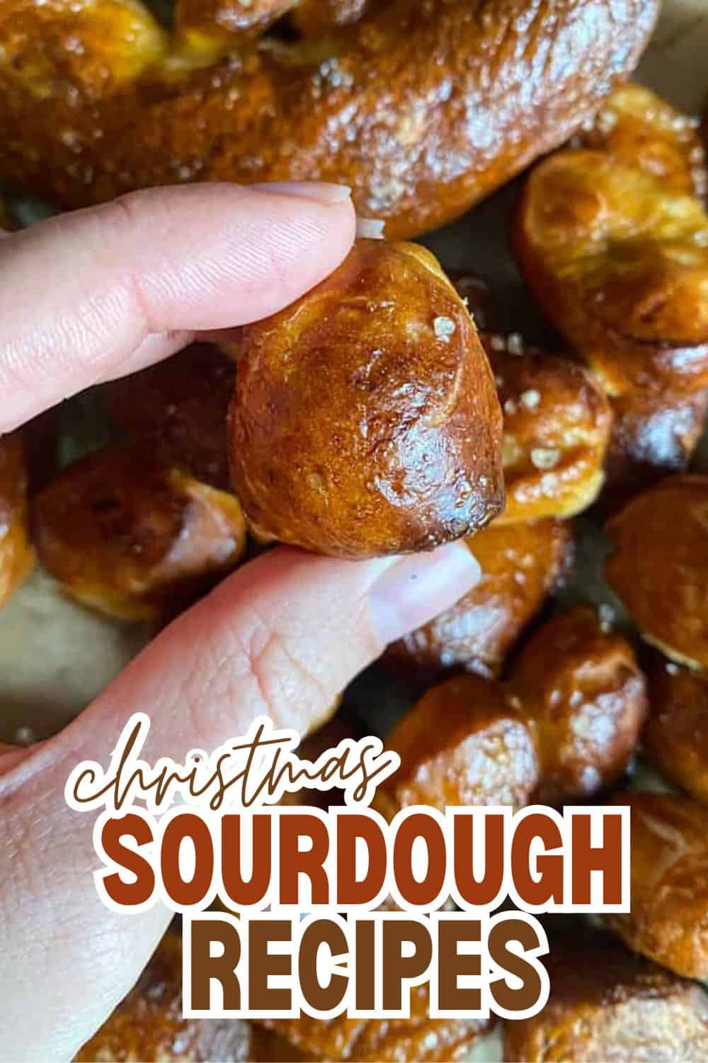 Close-up of a hand holding a golden sourdough bread bite for Christmas.