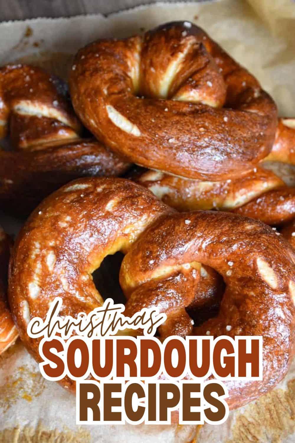 Close-up of golden-brown Christmas sourdough pretzels on parchment paper.