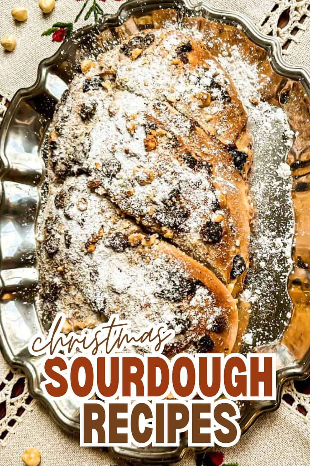 Christmas sourdough bread with dried fruits and powdered sugar on a decorative platter.