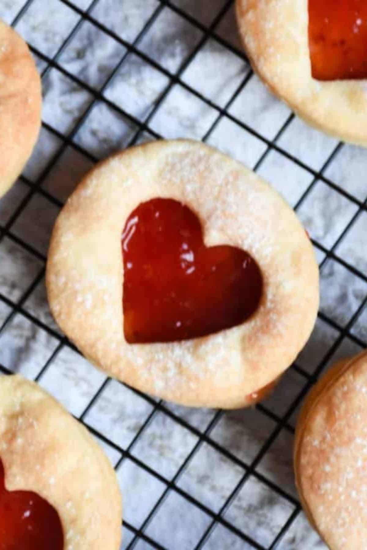 Delicious homemade cookies with heart-shaped jam centers, perfect for baking lovers and Valentine’s treats.