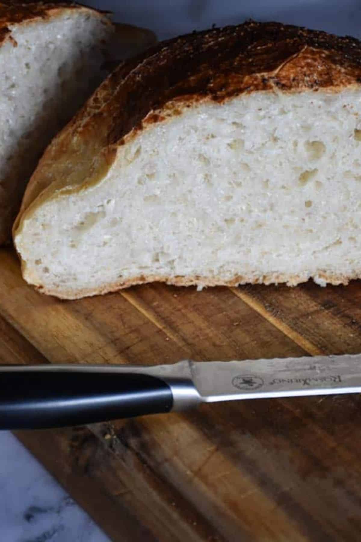 Artisan bread, crusty sourdough loaf, fresh baked bread on wooden board.